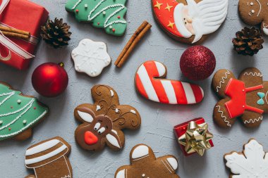Gri bir arka planda Noel kurabiyesi, baharat ve süslemeler..