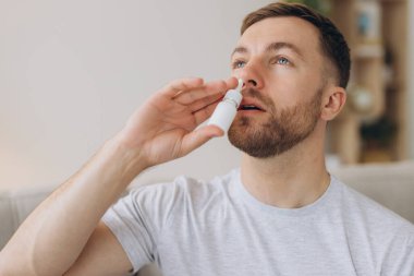 Hüsrana uğramış sağlıksız, hasta, alerjik bir adamın kırmızı gözleri var. Alerji yüzünden burnu akıyor. Semptomlar yüzünden.