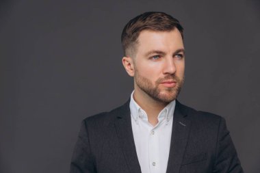 Kafkasyalı milenyum işadamı, gri stüdyo gerisinde izole edilmiş.