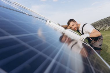 Fotovoltaik, güneş paneli ve bakım işçisi teftiş sırasında bina seviyesinde bir cetvel kullanıyor. Güneş enerjisi, yenilenebilir enerji ve insan elektriğin sürdürülebilirliğini kontrol ediyor.