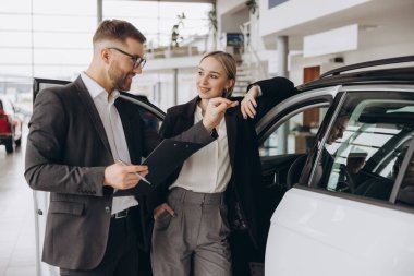Araba Satış Müdürü, Kafkasyalı Kadın Alıcıya Otomobil Galerisinde Otomobil Gösteriyor. Araç Konsepti Alınıyor