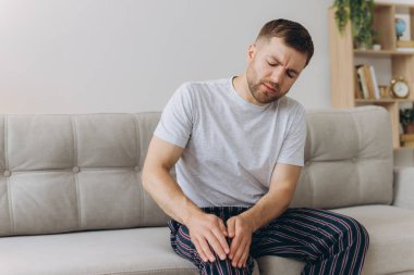 Evdeki kanepede oturan mutsuz adam acı ve ızdırap dolu dizine dokunuyor. Romatizması, eklem iltihabı ya da osteoartriti olan genç bir adam diz ekleminde şiddetli bir ağrı hissediyor.