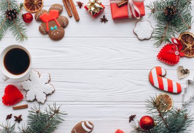 Zencefilli kurabiye, hediye, kahve ve mevsimlik süslemelerle süslenmiş bir Noel kutlaması. Sıcak ve davetkar sahneler yaratmak için mükemmel bir tatil teması..