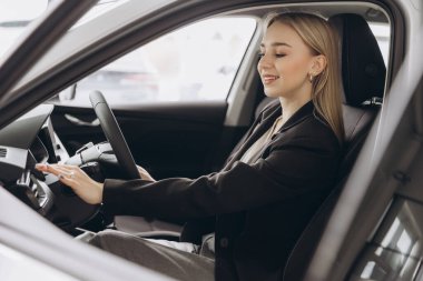 Başarılı bir iş kadını araba satın alır. Genç bir kadın pahalı bir alışverişin tadını çıkarıyor. Modern otomobil teknolojileri, test sürüşü ve sigorta kavramı.