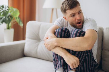 Depresyondaki umutsuz adam zihinsel çöküntü, psikoterapi, pankart boyunca kanepede yatar.