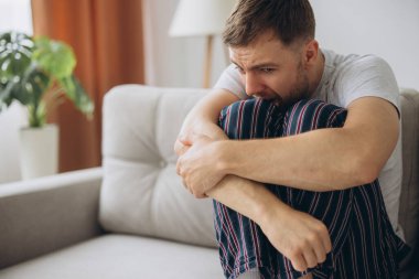 Depresyondaki umutsuz adam zihinsel çöküntü, psikoterapi, pankart boyunca kanepede yatar.