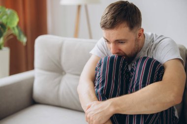 Depresyondaki umutsuz adam zihinsel çöküntü, psikoterapi, pankart boyunca kanepede yatar.