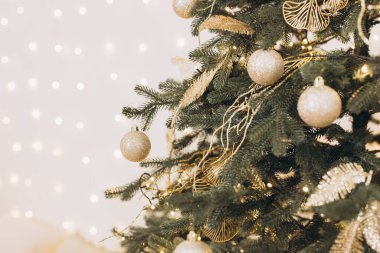 Altın mücevherlerle süslenmiş Noel ağacı, arka planda parıldayan ışıklar, neşeli ve büyülü bir atmosfer yaratıyor.