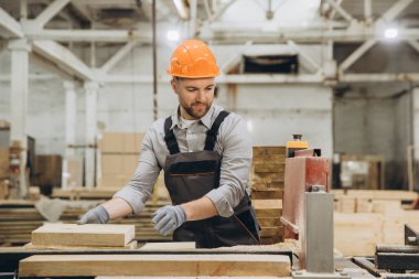 Marangoz tezgahta ahşap işliyor. Modüler inşaat endüstrisi için mobilya fabrikasında kereste fabrikası var.