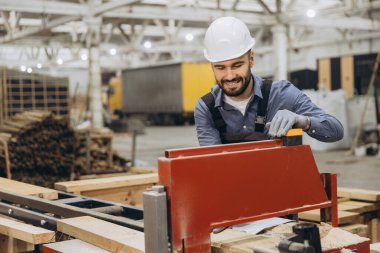 Gülümseyen marangozlar marangoz işletiyor, fabrikada kereste işletiyorlar, prefabrik ev elementleri üretiyorlar.
