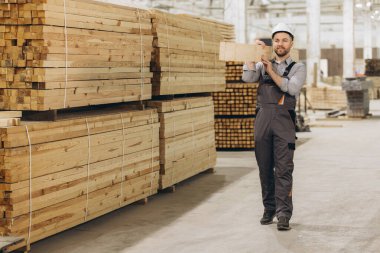 Marangoz büyük kereste deposunda ahşap kalas taşıyor, kereste üretimi endüstrisi...