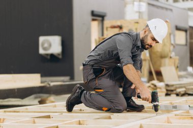 Marangoz modern fabrikada hassasiyet ve verimliliğe odaklanarak modüler yapı için prefabrik ahşap paneller kuruyor.