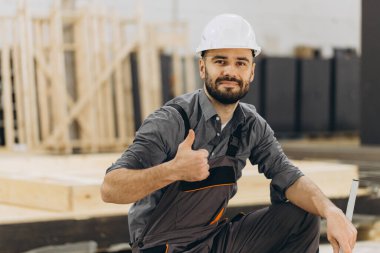 İnşaat işçisi prefabrik ev fabrikasında çalışırken, modüler yapı kalitesini ve verimliliğini temsil ederken,