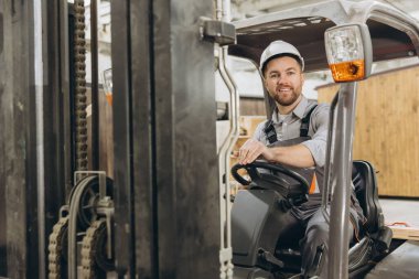 Endüstriyel depoda forklift kullanan kendine güvenen işçiler, modüler inşaat endüstrisinde malzeme taşımak, imalat alanında uzmanlık göstermek.