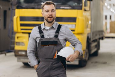 Miğfer tutan ve özel bir fabrikada prefabrik modüler bina nakliyesini denetleyen inşaat mühendisi.