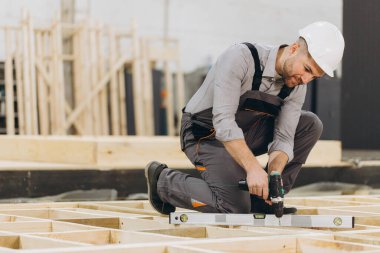 Yetenekli marangozlar fabrikada ahşap paneller kuruyor, aletlerle hassasiyete odaklanıyor, inşaat endüstrisinde uzmanlık ve tutku sergiliyor.