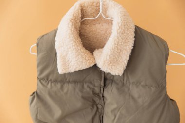 Askıda asılı koyun derisi kaplamalı kolsuz yastıklı ceketi kapat. Tasarımlarını gerçekçi bir ortamda sergilemek için mükemmel.