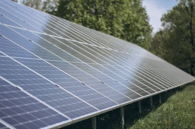 Large solar panels capturing sunlight in a green field, generating clean and sustainable energy clipart