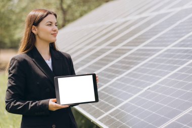 İş kadını boş ekranlı tablet gösteriyor yenilenebilir enerji ve güneş paneli teknolojisini destekliyor