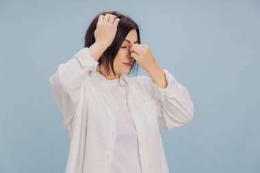 Esmer kadın şiddetli baş ağrısı, sinüs ağrısı ve sağlık sigortası konsepti nedeniyle kafasına ve burnuna dokunuyor.