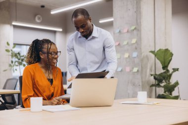 Afrika kökenli Amerikalı meslektaşlar çağdaş bir ofiste birlikte çalışıyorlar, teknolojiyi üretkenliği ve yaratıcılığı arttırmak için kullanıyorlar. Çeşitli takımlar fikirleri paylaşıyor
