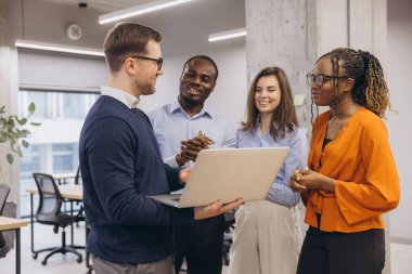 Profesyonel ekip stratejiyi tartışıyor, parlak modern çalışma alanında birlikte çalışıyor, kurumsal işbirliği ve işyeri çeşitliliğini temsil ediyor