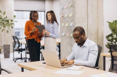 Çağdaş bir ofis ortamında takım çalışması ve teknoloji ile ilgilenen profesyoneller, üretkenliği ve yeniliği teşvik ediyorlar.