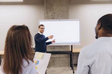 İş toplantısında işbirliği yapan profesyoneller, modern bir ofiste dijital görüntü kullanarak veri analizi ve stratejik planlamalara odaklanıyorlar.