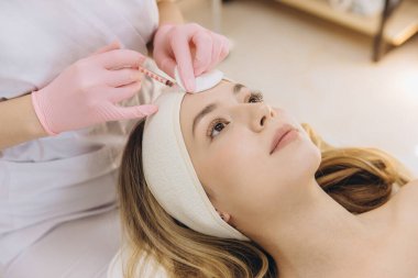 Cilt bakımı kliniğinde estetik ameliyat sırasında sarışının tedavisine meydan okuyan profesyonel enjeksiyon yaşı
