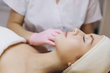 Kozmetik uzmanı, cilt geliştirme ve dış hatlar için kadın hastaların dudaklarına cilt dolgusu enjekte ederek dudak büyütme ameliyatı yapıyor.