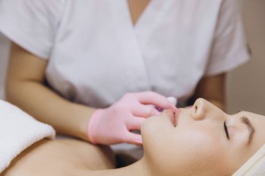 Kozmetik uzmanı, cilt geliştirme ve dış hatlar için kadın hastaların dudaklarına cilt dolgusu enjekte ederek dudak büyütme ameliyatı yapıyor.