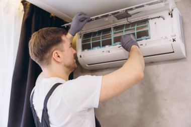 Tesisatçı, bir havalandırma ünitesinin bakımını üstlenerek yerleşim alanındaki en uygun soğutma ve havalandırmayı sağlıyor.