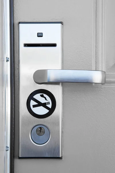 Modern door handle with security system lock and no smoking sign