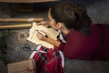Esmer kız Noel Baba 'ya mektup yazıyor.