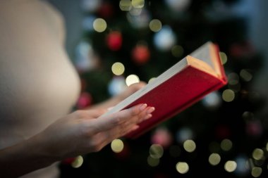 Close up woman holding book with stories christmas clipart