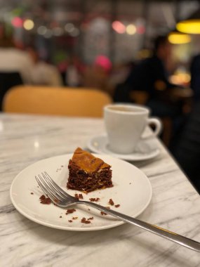 Leftover Bitten Brownie Cake at Cafe Restaurant with Coffee and Fork.