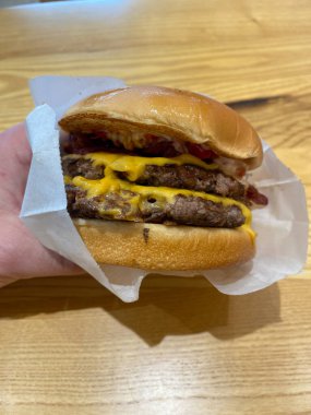 Take Away Double Cheeseburger Hand Hold Take Out at Fast Food Restaurant. Ready to Bite.