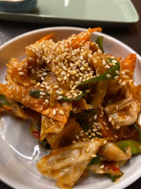 Baharatlı Kore mayalanmış yiyecek yıllanmış kimchi lahanası susam tohumlarıyla makro görüntüyü kapatın. Geleneksel yemek.