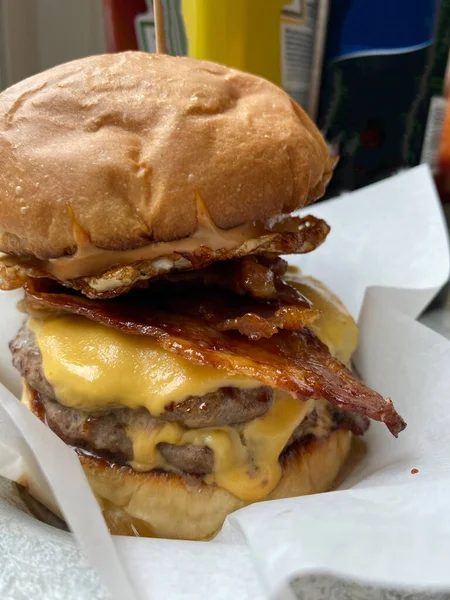 Hamburger with Bacon and Cheddar Cheese. Macro Close Up View. Cheeseburger Double Burger. Ready to Eat.