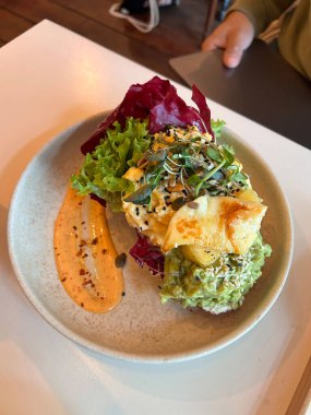 Avokado, kabak tohumu ve soslu Halloumi tostu. Yemek için hazır..