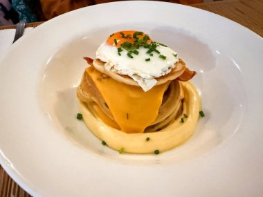 Yumurtalı tuzlu krep, çedar peyniri sosu ve restoranda servis edilen pastırma. Yemek hazır.