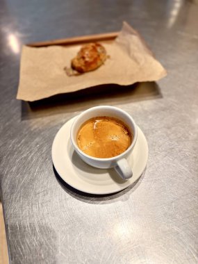 Kahve dükkanında servis edilen tahıllı hamur işiyle birlikte Americano kahvesi.