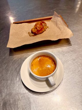 Kahve dükkanında servis edilen tahıllı hamur işiyle birlikte Americano kahvesi.