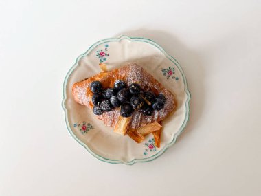 Krema ve şeker tozlu ev yapımı yabanmersini kruvasanı.