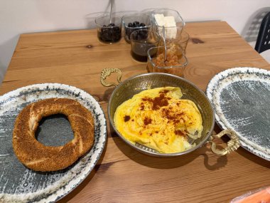 Ev yapımı Türk kahvaltısı ve ahşap masada simit. Yemek hazır.