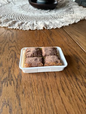 Traditional Turkish dessert cold baklava in the plate. Geleneksel Soguk baklava on wooden table. clipart