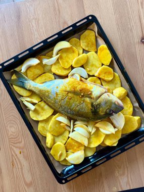 Altın kavrulmuş patatesle servis edilen (dorade olarak da bilinir) güzel pişmiş bir deniz kestanesi..