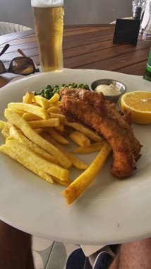 Restoranda bezelye ve patates ile servis edilen tavuk kanadı.