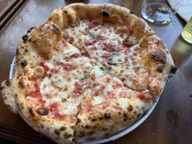 Tuğla fırınından ev yapımı Napolili pizza margaritası. Napolyon İtalyan pizzası, taze mozarella ve fesleğen yapraklı. Restoranda gerçek İtalyanca