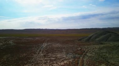 Tepenin üzerinden uçup tepeye doğru güzel manzara renkleri sarı-yeşil-kırmızı mangystau kazakistan